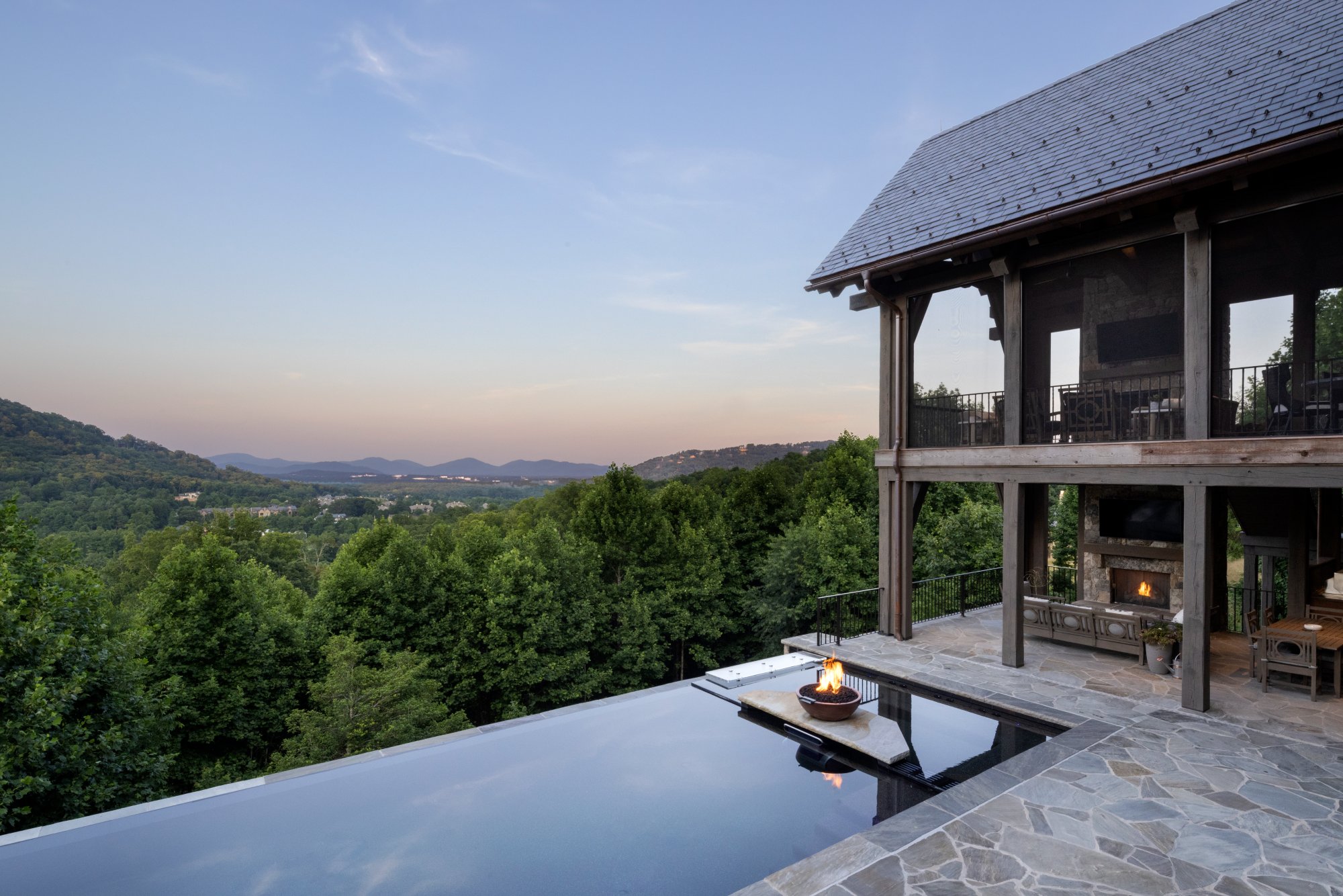 Infinity edge pool with fire bowl, outdoor screen porch with fireplace 