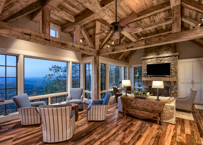 Open concept dining and living room, reclaimed wood ceiling timbers and beams, stone fireplace 