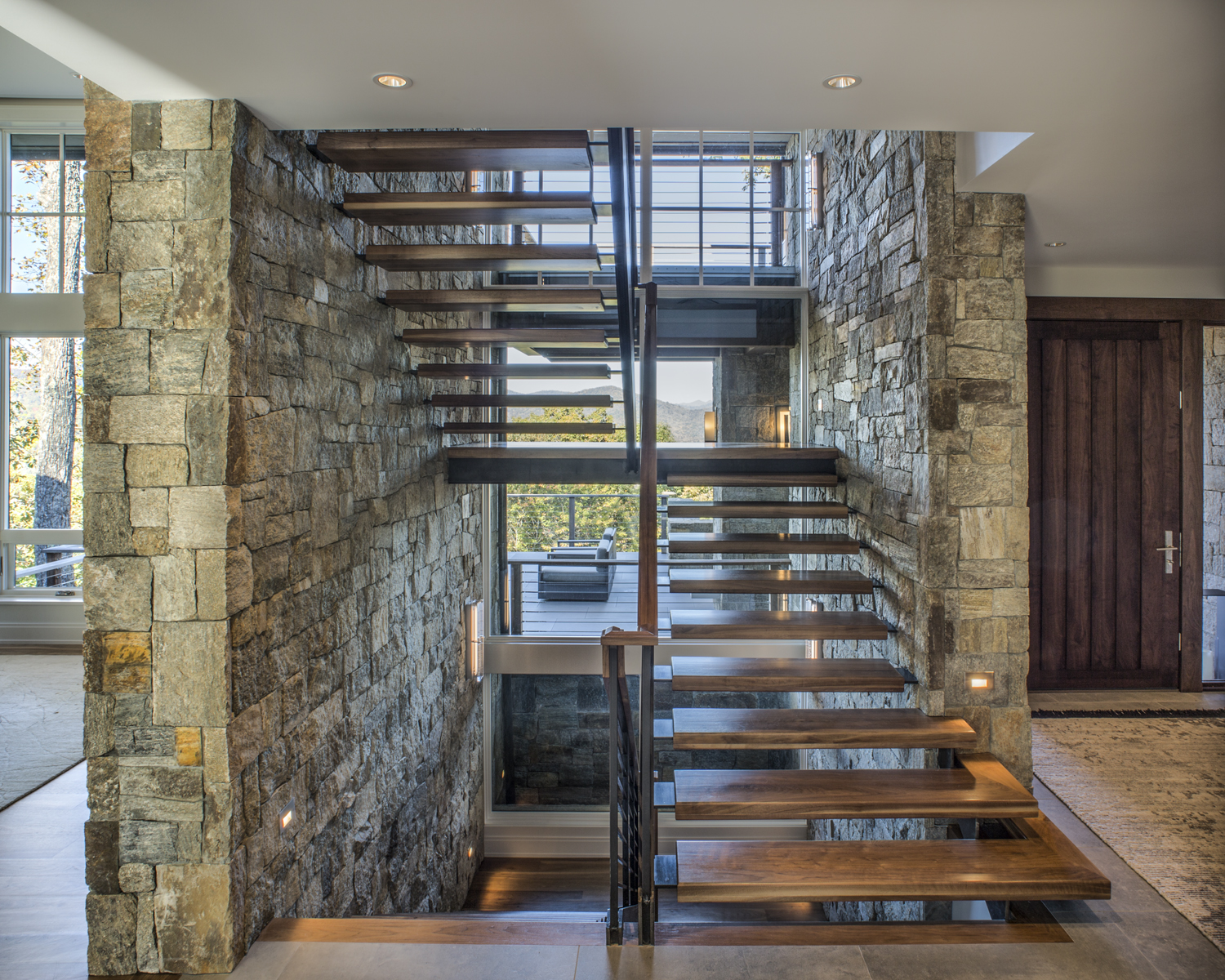 Modern walnut steel floating staircase stone wall